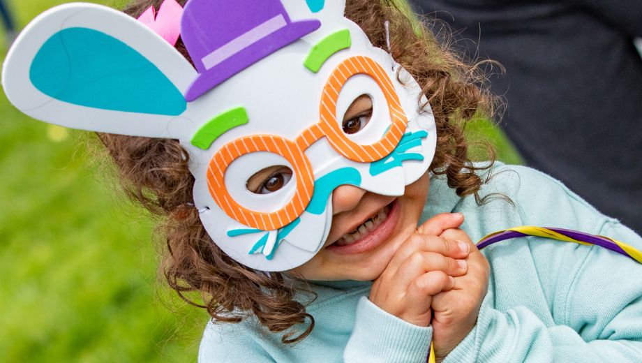 Child in bunny mask smiles at camera